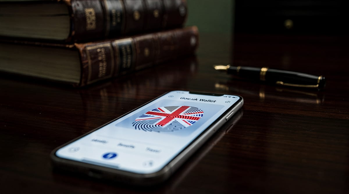 Close-up of a digital infrastructure map resembling a spiderweb, glowing in neon blue against a dark background. The center of the web is a padlock labelled 'Central Database', which is cracked and leaking binary code like blood. Around the edges, indistinct hackers in hoodies are siphoning data. The aesthetic is cyber-noir, high contrast, emphasizing the vulnerability of centralized systems. Photorealistic rendering, depth of field focused on the broken lock.